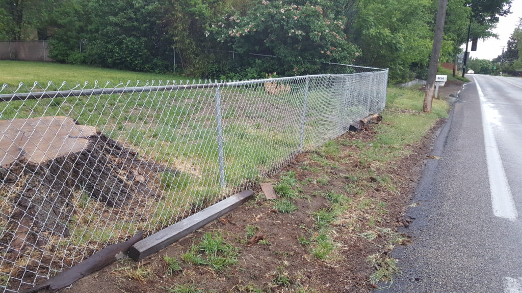 Image of fence that was previously bent by tree limbs coming down.