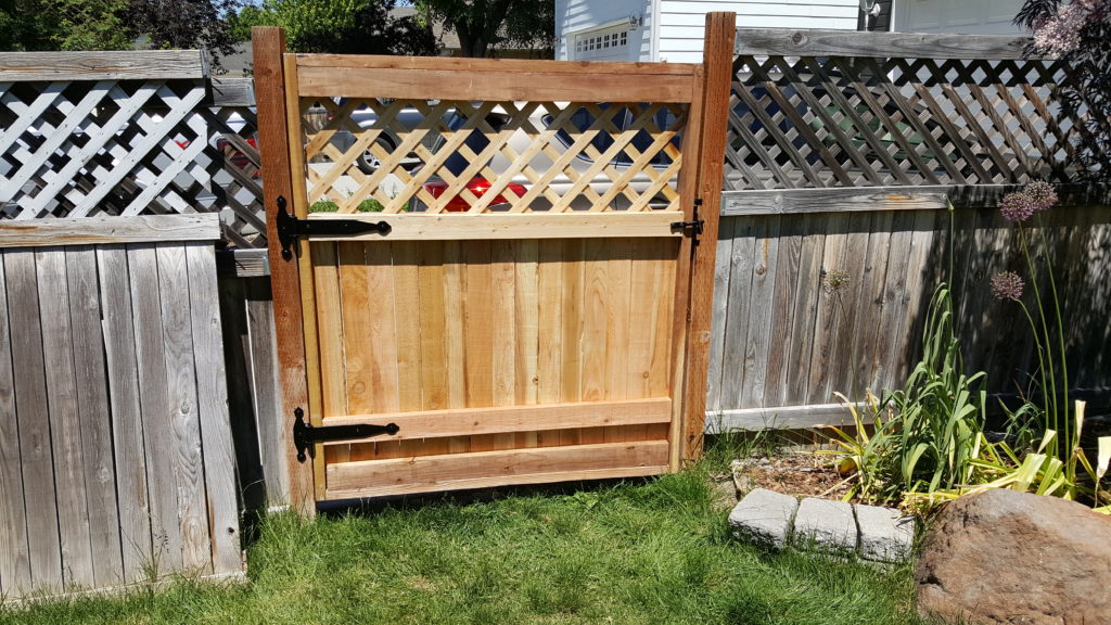 The backside Image of a new gate on an old fence