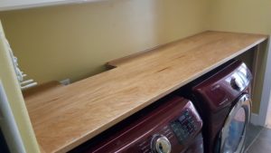 Image is of table built for folding clothes in laundry room