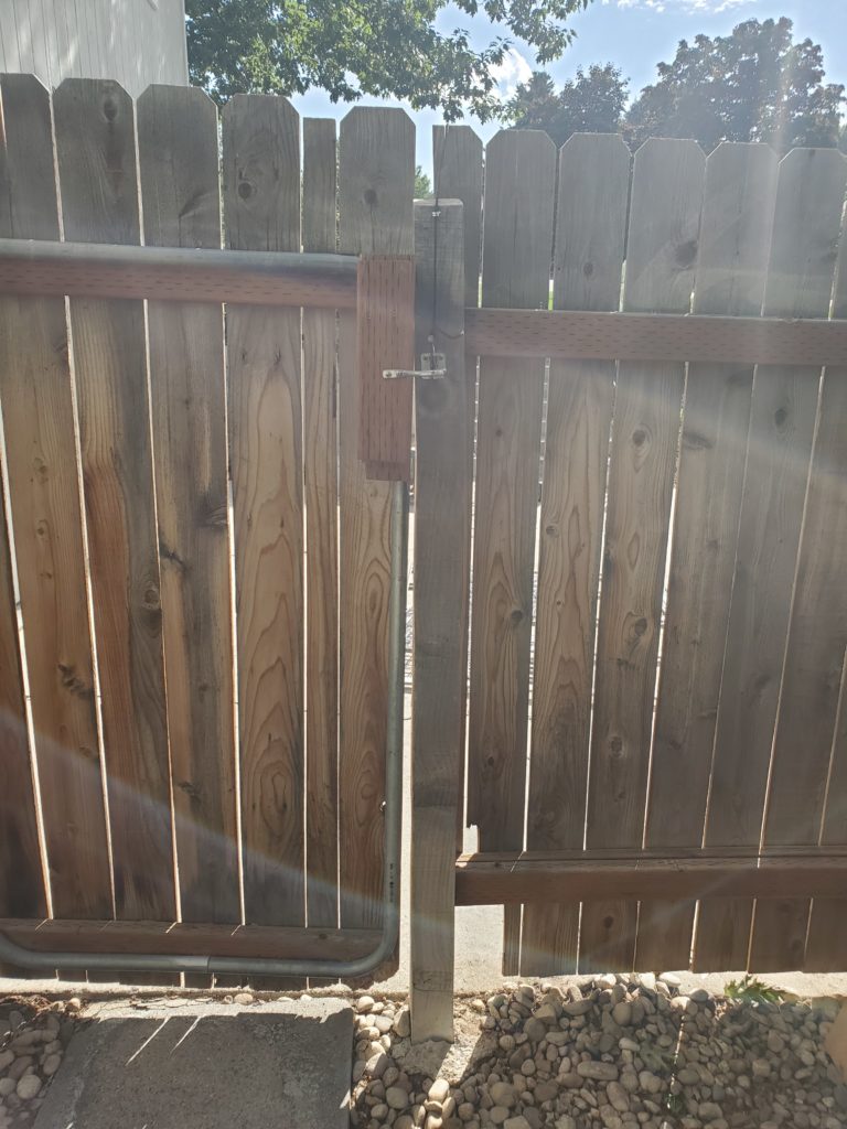 Image opf the backside of a gate/fence being repaired with cedar pickets